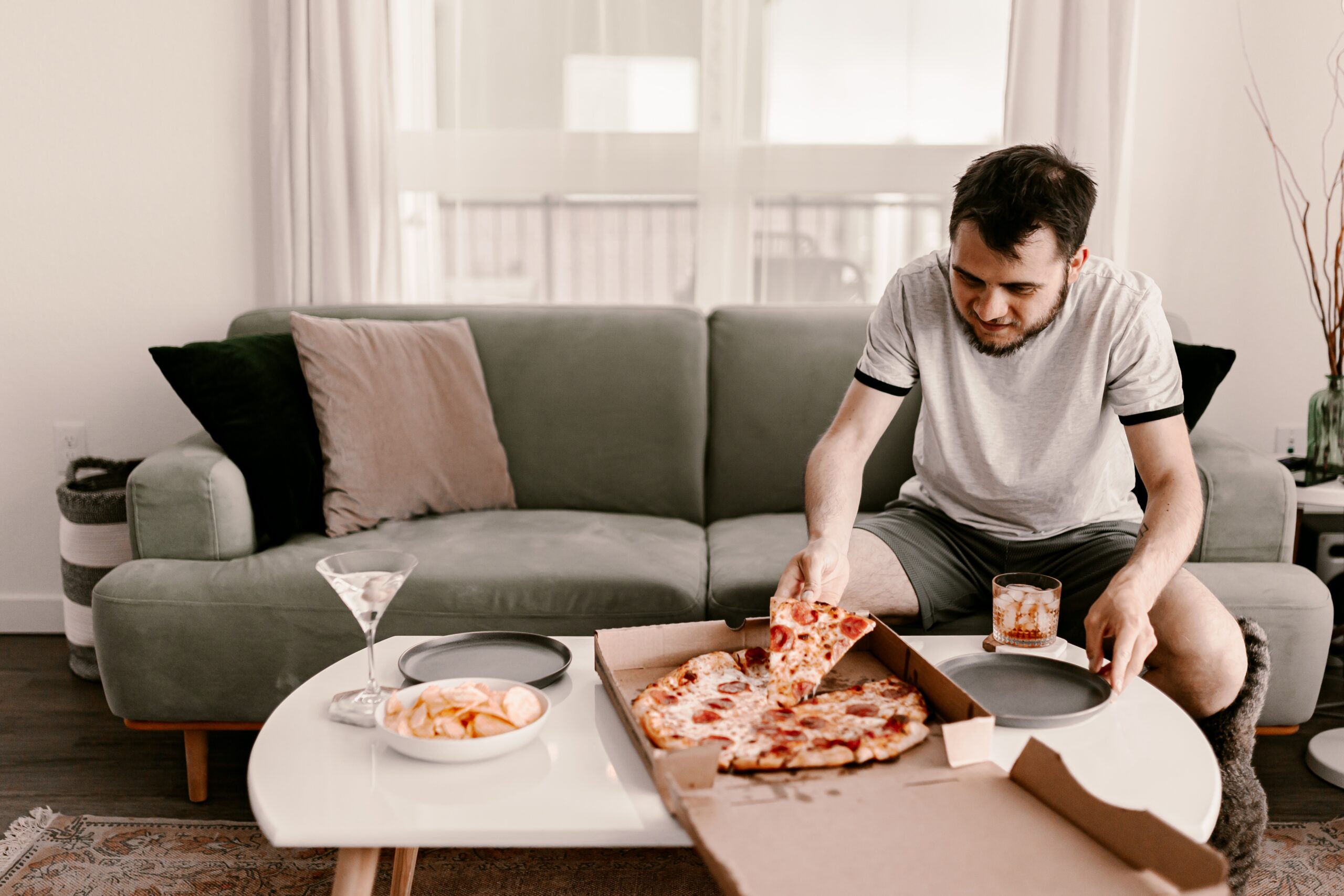 Food delivery. Ordering dinner online from the restaurant. New York style pizza and movie night. Family meal at home. Pepperoni and cheese topping. Cardboard box. Friday party. Comfort food.